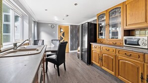 Een moderne keuken met houten kastjes, een ingebouwde magnetron en een grote koelkast.