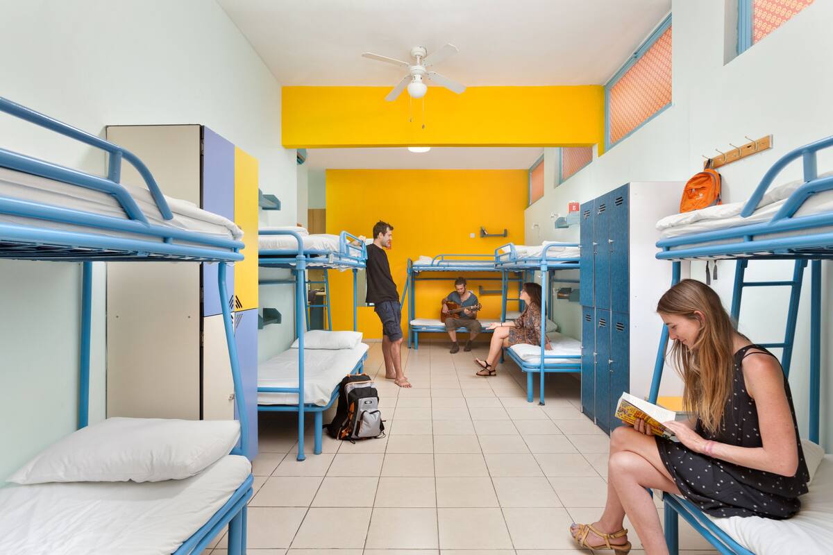 A dormitory room with bunk beds, a ceiling fan, and lockers.