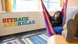 A room with a hammock, a colorful striped rug, and a wall with the words "SITBACK AND RELAX". - Abraham Jerusalem  (Jerusalem)