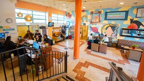 A brightly lit indoor space with a central seating area, a reception desk, and a mural on the wall. - Abraham Jerusalem  (Jerusalem)