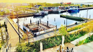 A waterfront area with a dock, boats, and a restaurant with outdoor seating. - Hotel Gammel Havn - Good Night Sleep Tight (Fredericia)