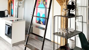 A modern kitchen with wooden beams, a stainless steel sink, and a black metal ladder. - Hotel Gammel Havn - Good Night Sleep Tight (Fredericia)