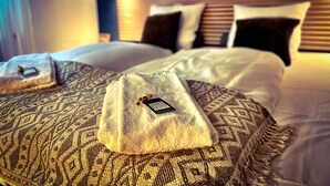 A hotel room with a neatly made bed, two pillows, and a small decorative item on the bed. - Hotel Gammel Havn - Good Night Sleep Tight (Fredericia)