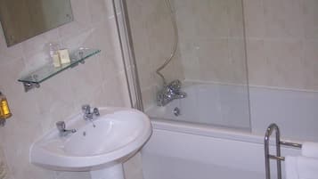 Un baño con lavamanos, espejo, ducha e inodoro.