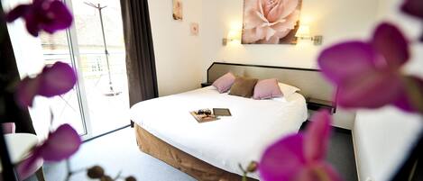 Un dormitorio con cama, mesita de noche, ventana y lámpara de pared.