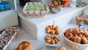 A buffet table with various food items, a television, and a decorative vase. - Amadour Hôtel (Rocamadour)