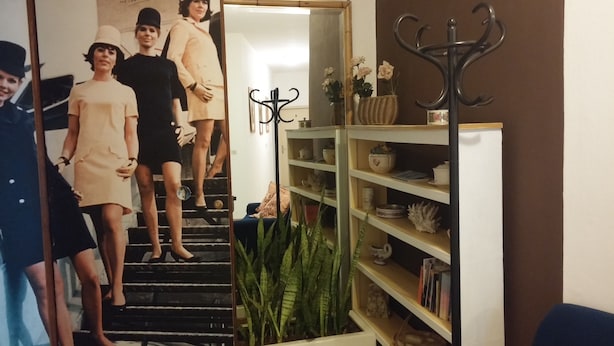 Un escalier menant à une pièce où se trouvent une bibliothèque et des objets de décoration.