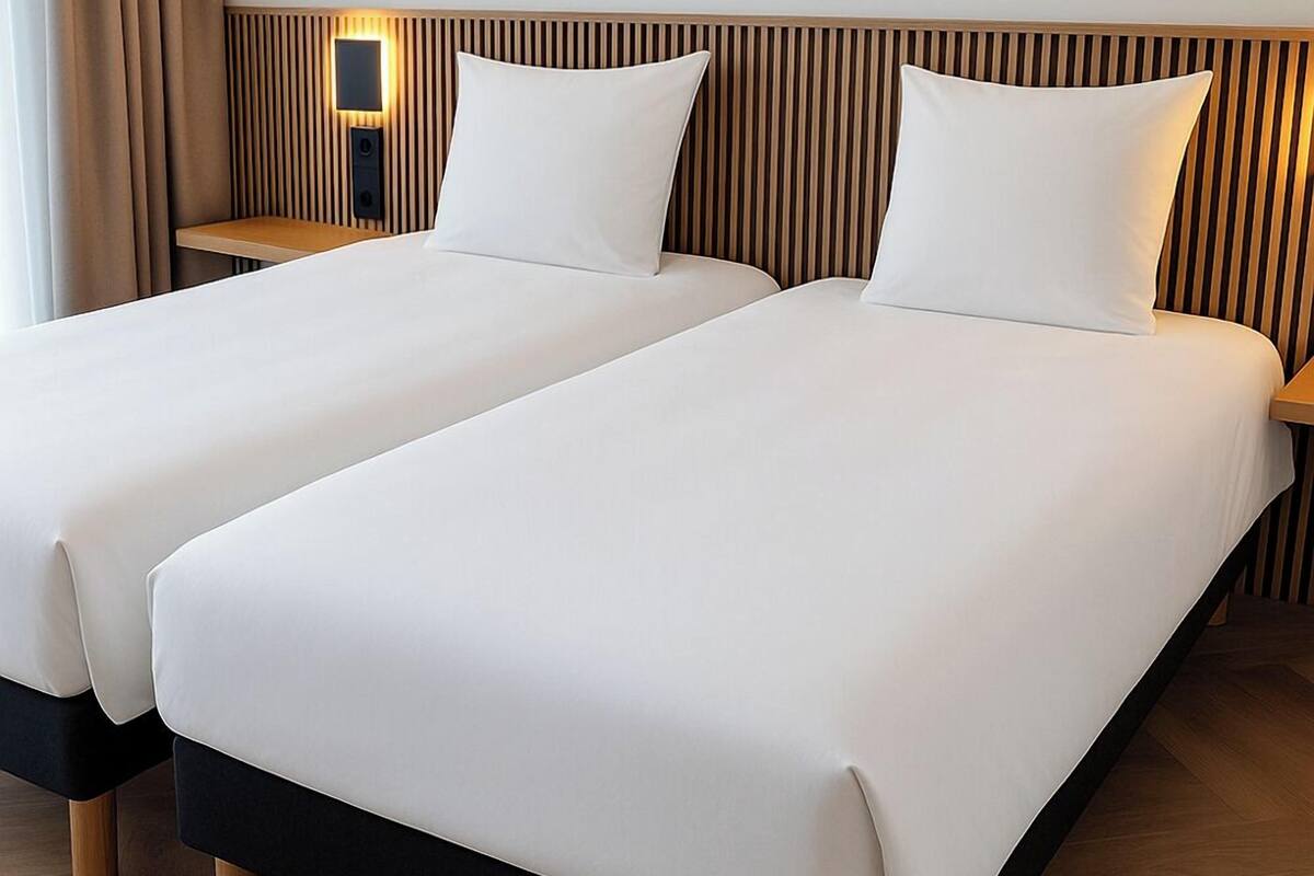 A double bed with a wooden headboard and a bedside table with a lamp.