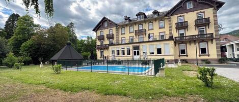 Un hotel grande con varios balcones y una piscina.