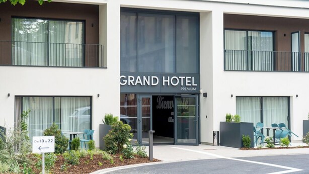 Un hôtel moderne, reconnaissable à son enseigne où l’on peut lire : « GRAND HÔTEL PREMIUM ».