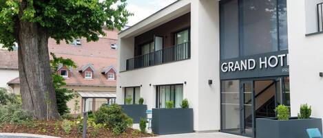 Een modern hotel met een groot bord waarop 'GRAND HOTEL' staat.