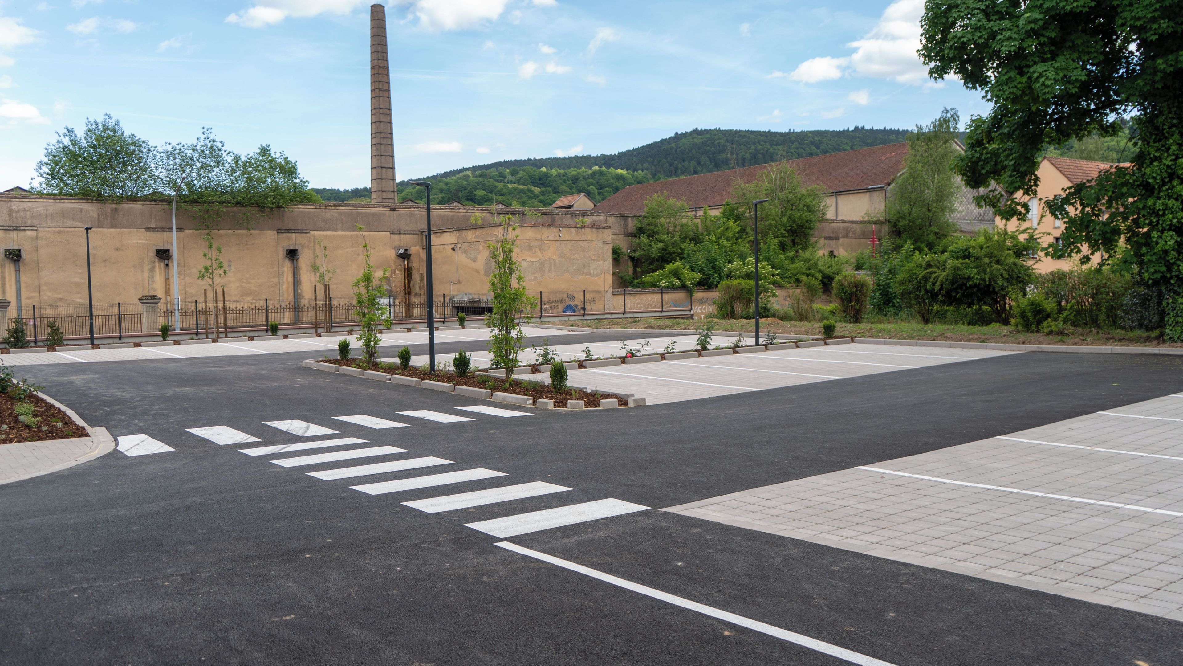 A parking lot with marked crosswalks and a pedestrian path.