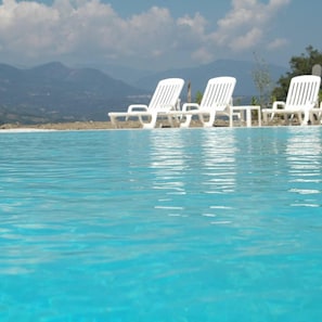 Alberca al aire libre, acceso de 10:00 a 18:00, y camastros