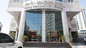 A modern building with a curved facade, large glass windows, and a sign indicating it is a hotel. - Retaj Residence Al Corniche (Doha)
