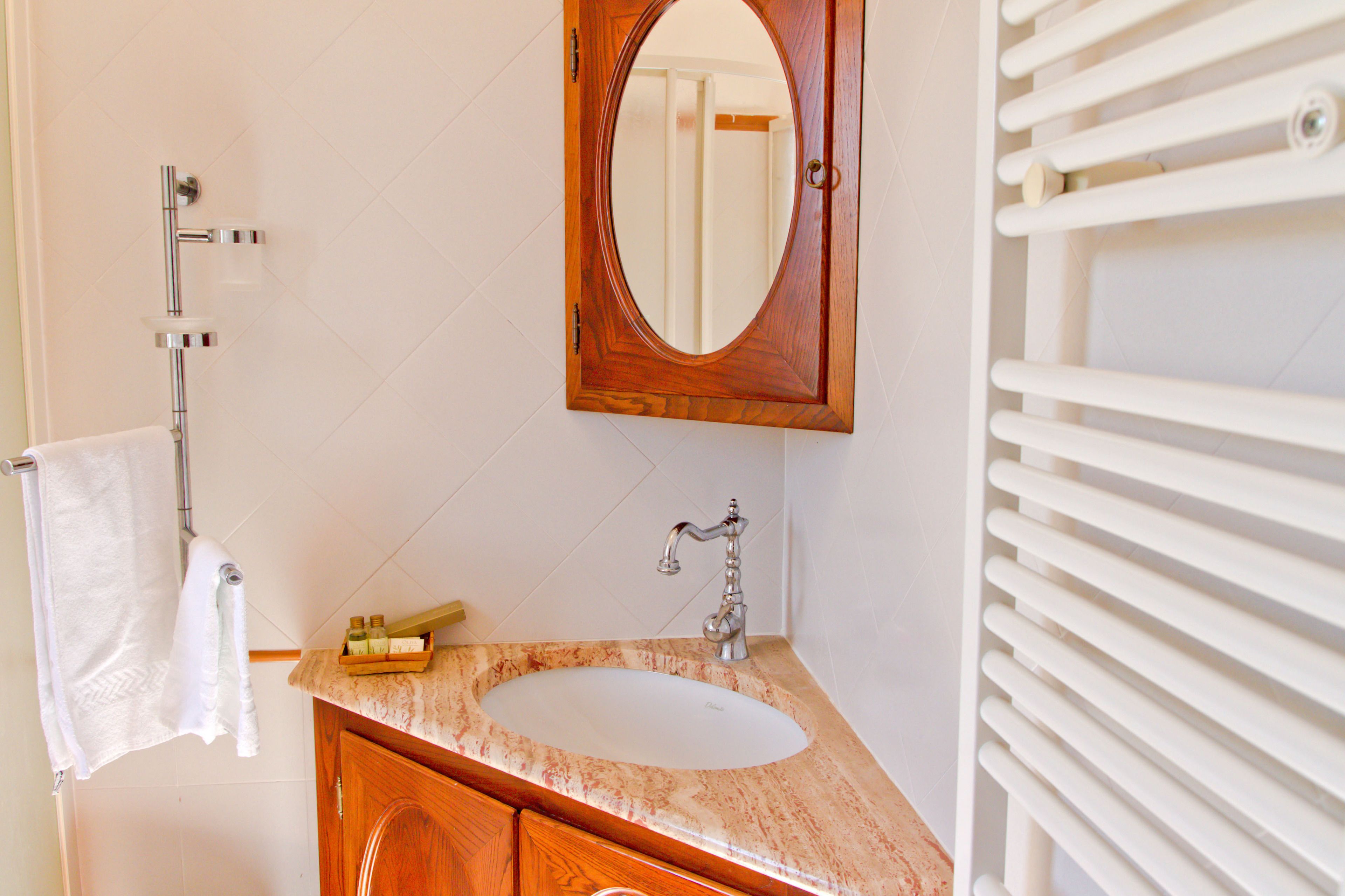 Une salle de bain avec un meuble-lavabo en bois, un lavabo blanc et un miroir au-dessus.