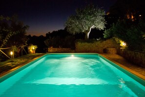 Una piscina al aire libre de temporada, sombrillas