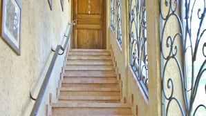 Un escalier en briques mène à une porte en bois située en haut.