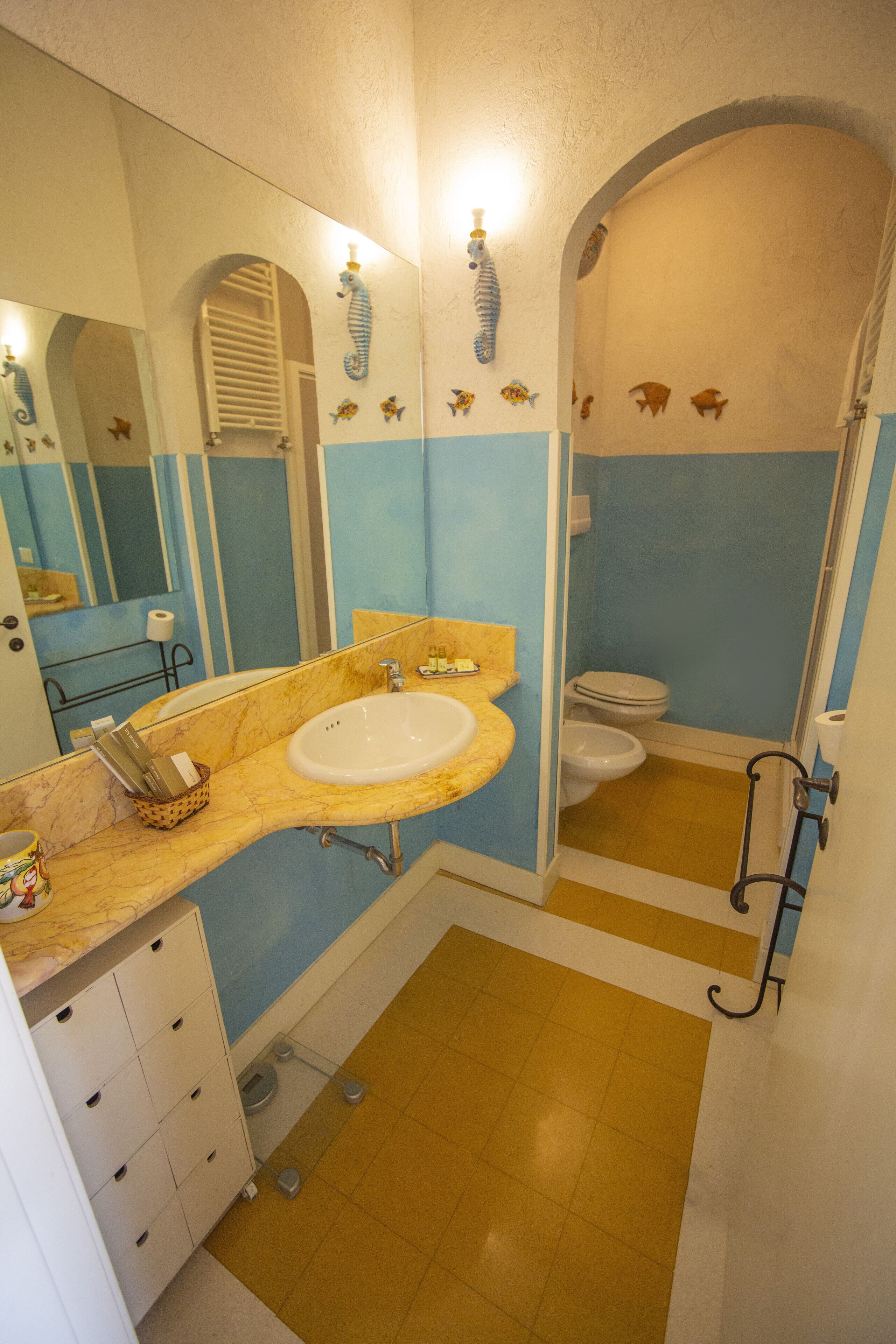 Un baño con lavamanos, espejo y retrete.