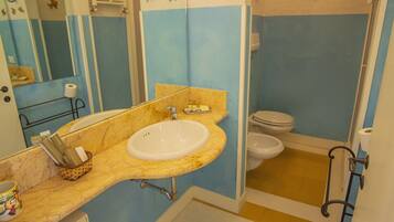 Un baño con lavamanos, espejo y retrete.