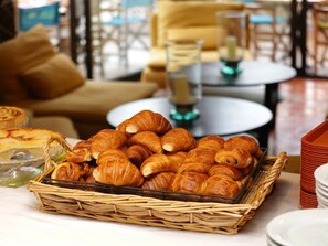 Een ontbijtbuffet met croissants en gebak.