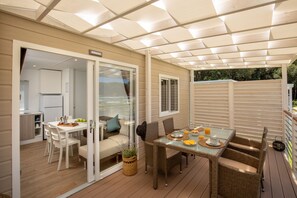 A covered patio area with a dining table, chairs, and a sofa. - Camping Village Parco della Gallinara (Anzio)