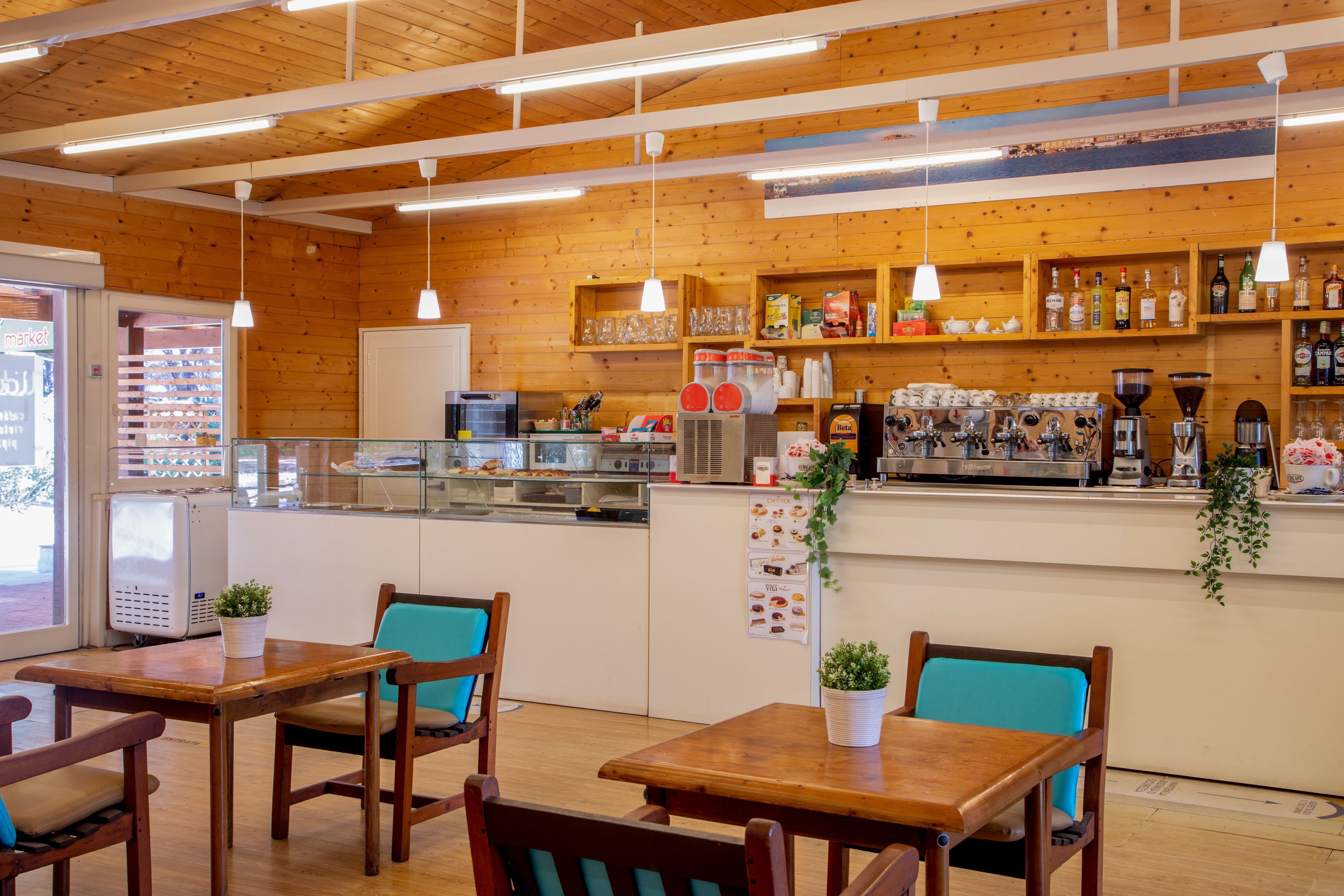 A cozy cafe with wooden interior, tables, chairs, and a coffee bar.