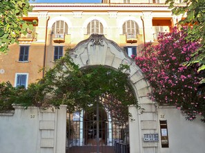 A building with an ornate archway, numbered 25, and a sign indicating a sale. - Palma Residences In Rome (Rome)