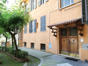 A building with a wooden door, shutters, and a tiled roof. - Palma Residences In Rome (Rome)