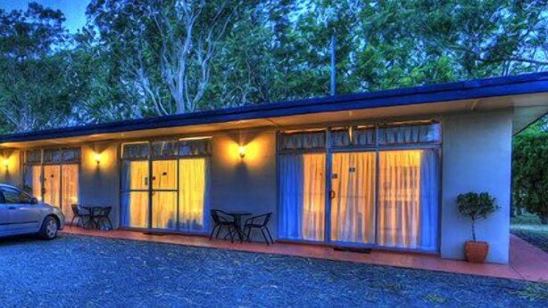 A motel with a row of rooms, each with a door and windows, and a covered outdoor area with tables and chairs. - All Seasons Country Lodge (Taree South)