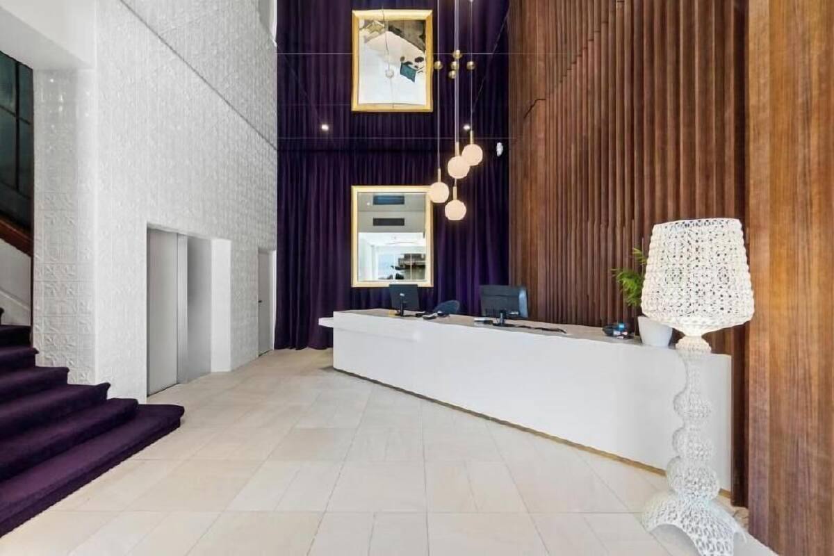 A reception desk with a modern design, a staircase, and a wooden panel wall.