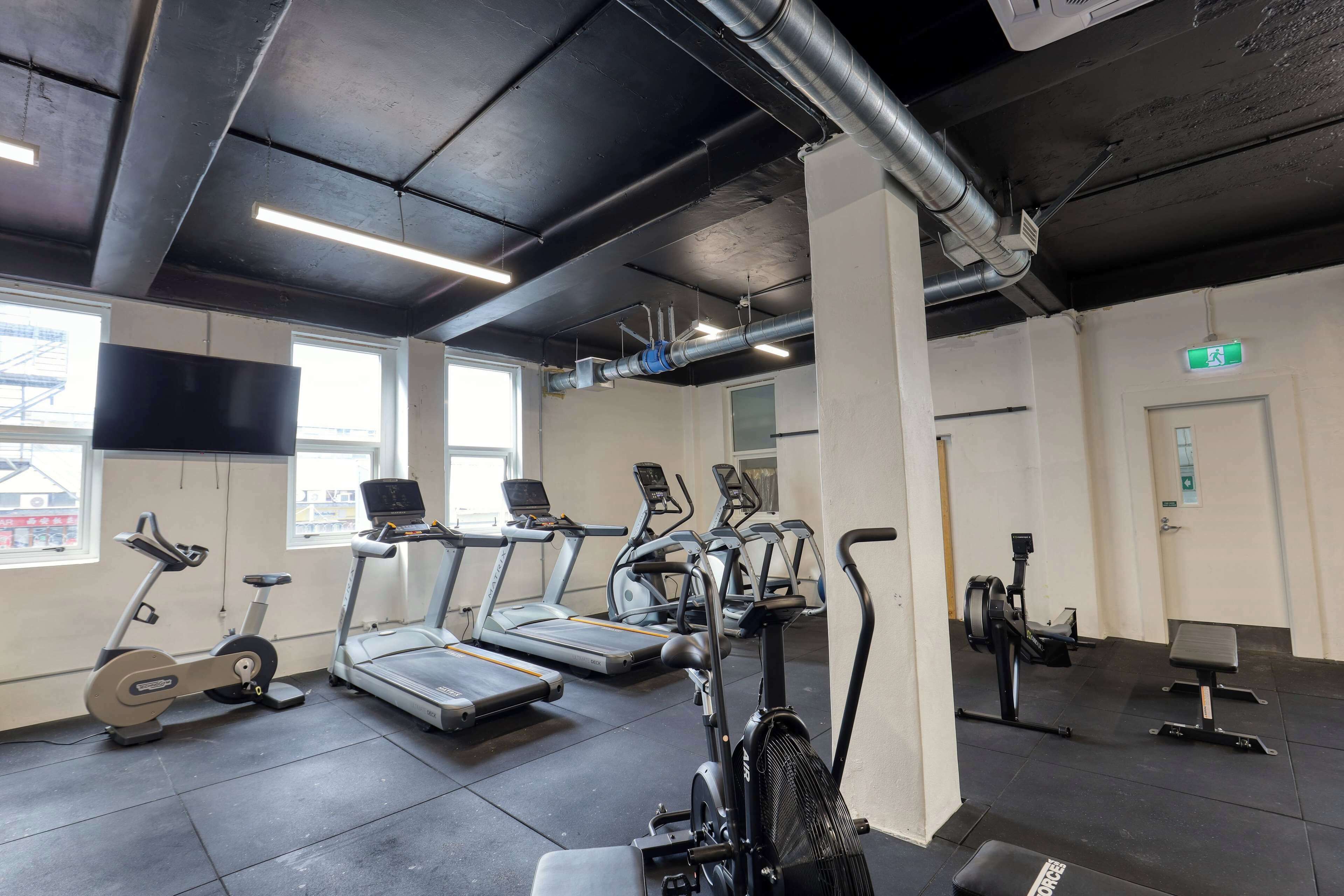 A gym with treadmills, stationary bikes, and a rowing machine.