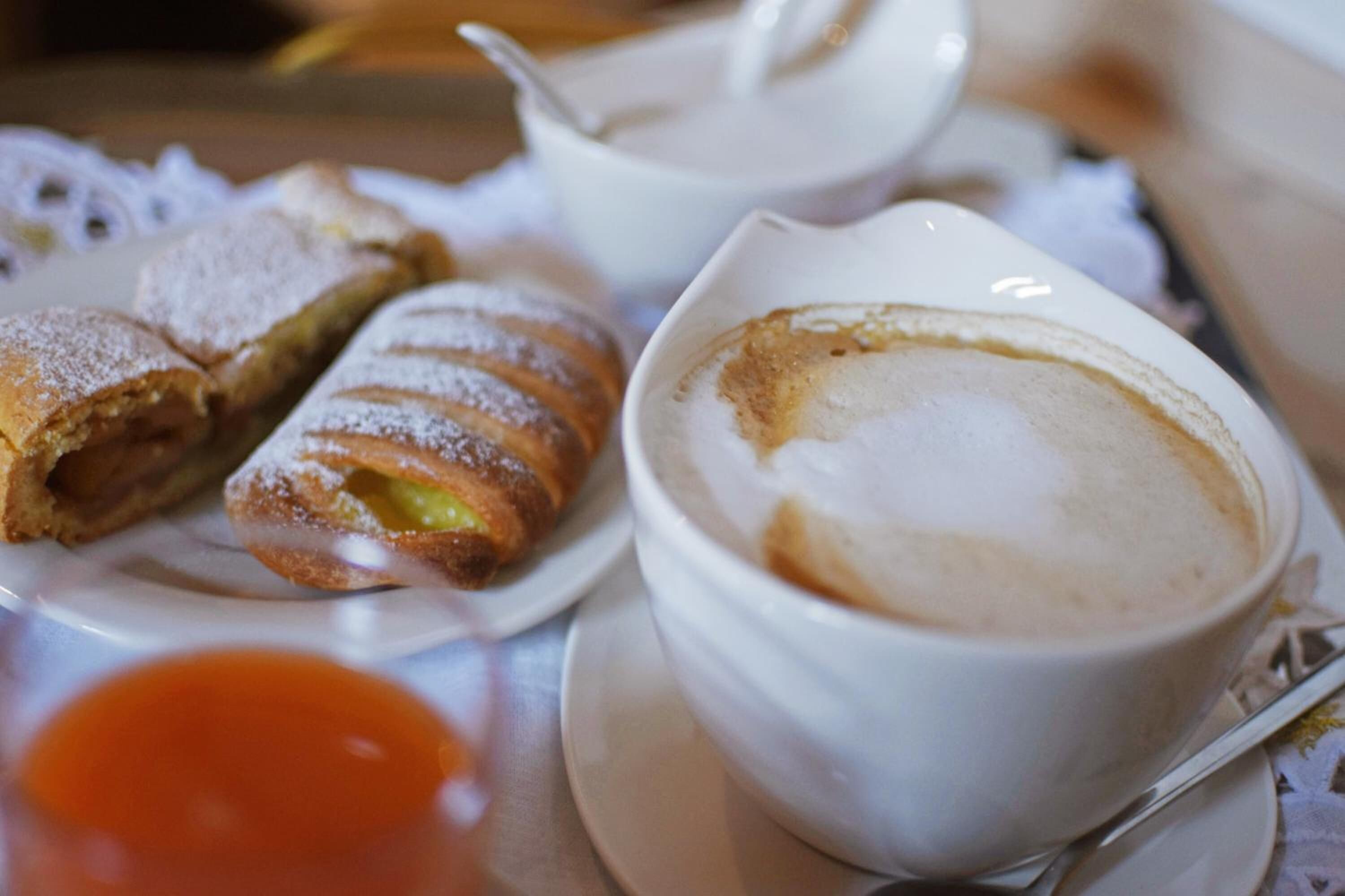 Een gedekte tafel met gebakjes en een kop koffie.