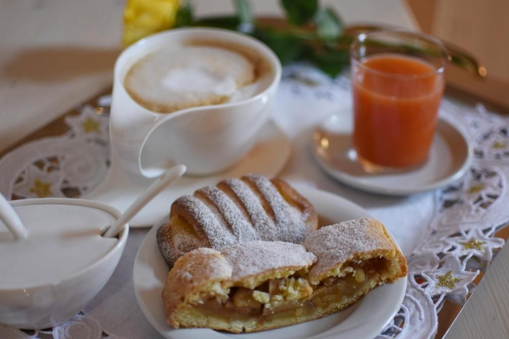 Taula preparada amb un pastís, una tassa de cafè i un got de suc.