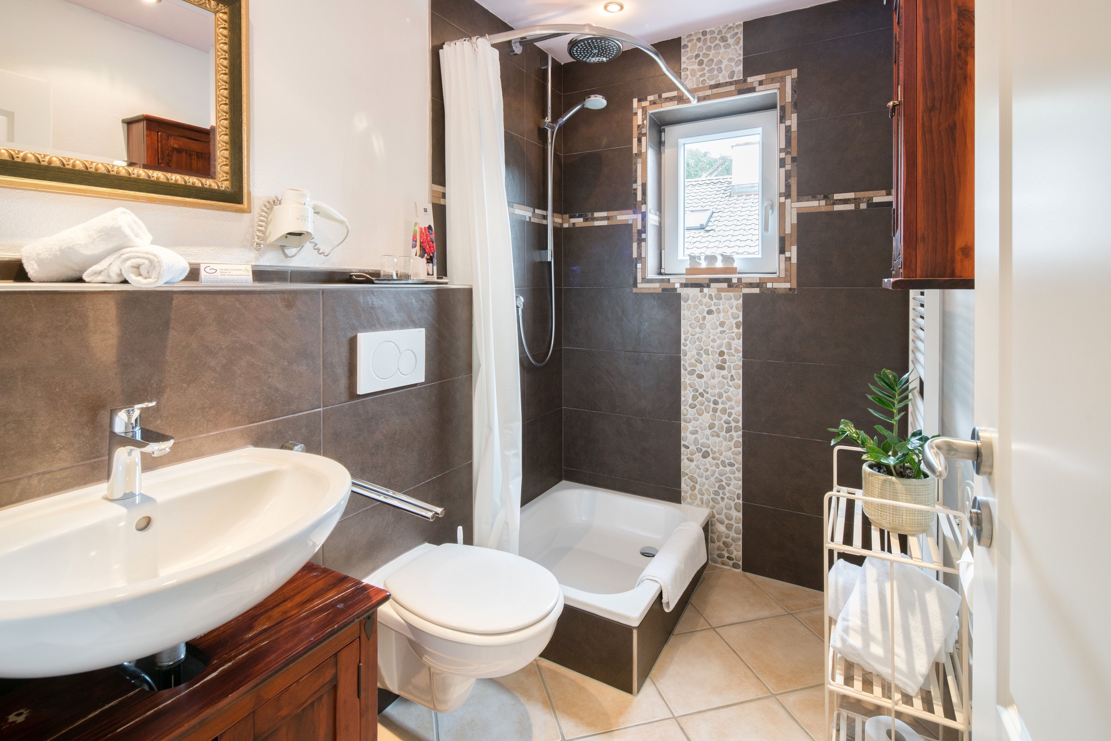 A modern bathroom with a sink, toilet, bathtub, and shower.