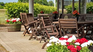 A patio area with wooden furniture and potted plants.