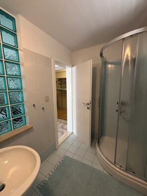 A bathroom with a sink, a glass shower enclosure, and a tiled floor. - Villa Mandolina Apartments (Zadar)
