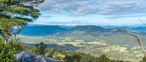 A tented accommodation with a panoramic view of a mountainous landscape.