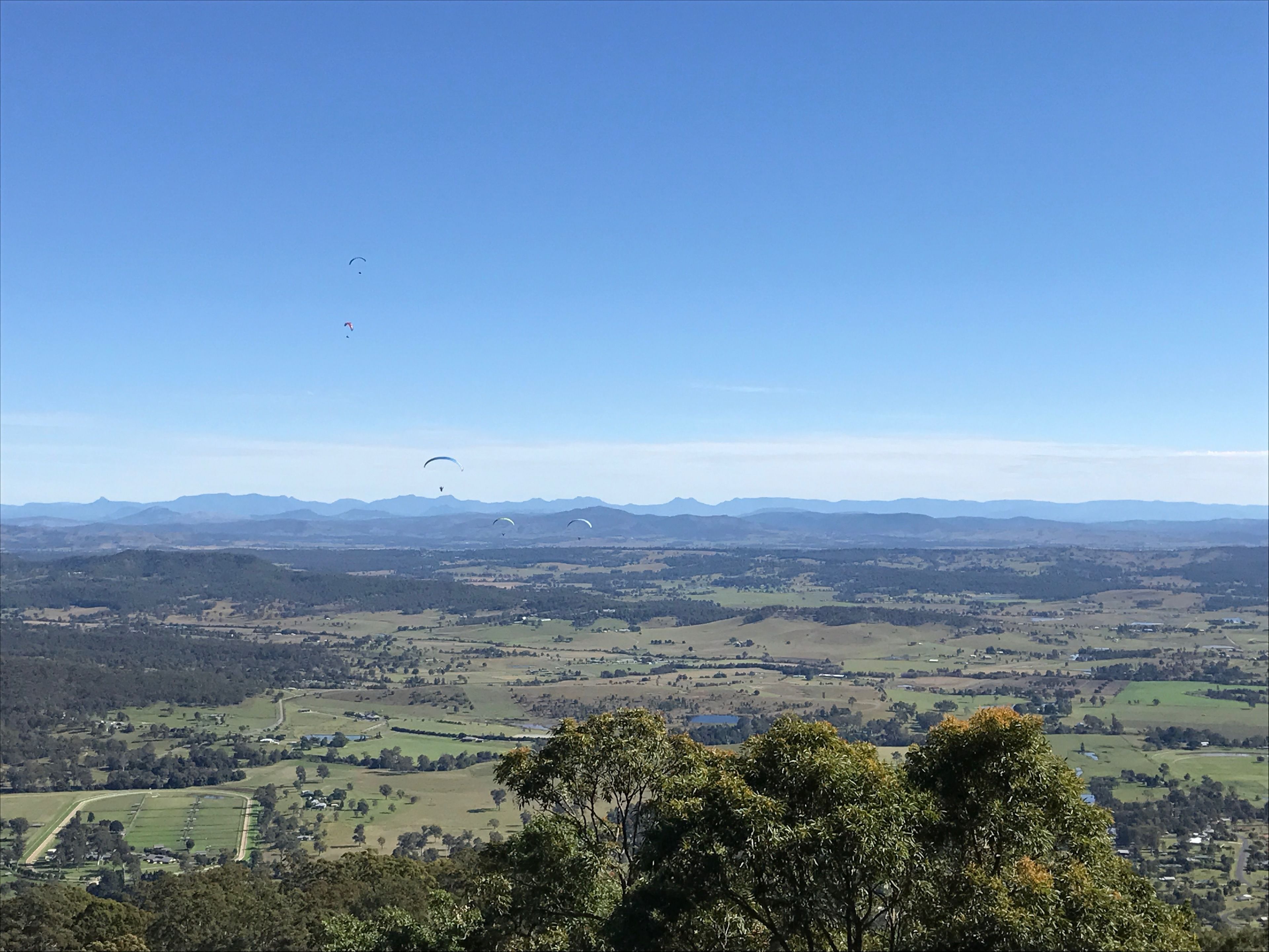 A panoramic view of a rural landscape with rolling hills and a clear blue sky.