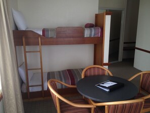 A bunk bed with a ladder, a small table with a notebook, and two chairs. - The 3 Explorers Motel (Katoomba)