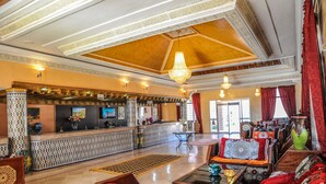 A lobby with a reception desk, patterned columns, and traditional furnishings. - Hôtel Saghro (Tinghir)