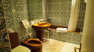 Un baño de diseño tradicional, con inodoro, lavabo y zona de ducha.