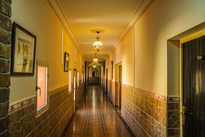 A long, narrow hallway with tiled walls and a tiled floor, leading to a door at the end. - Hôtel Saghro (Tinghir)