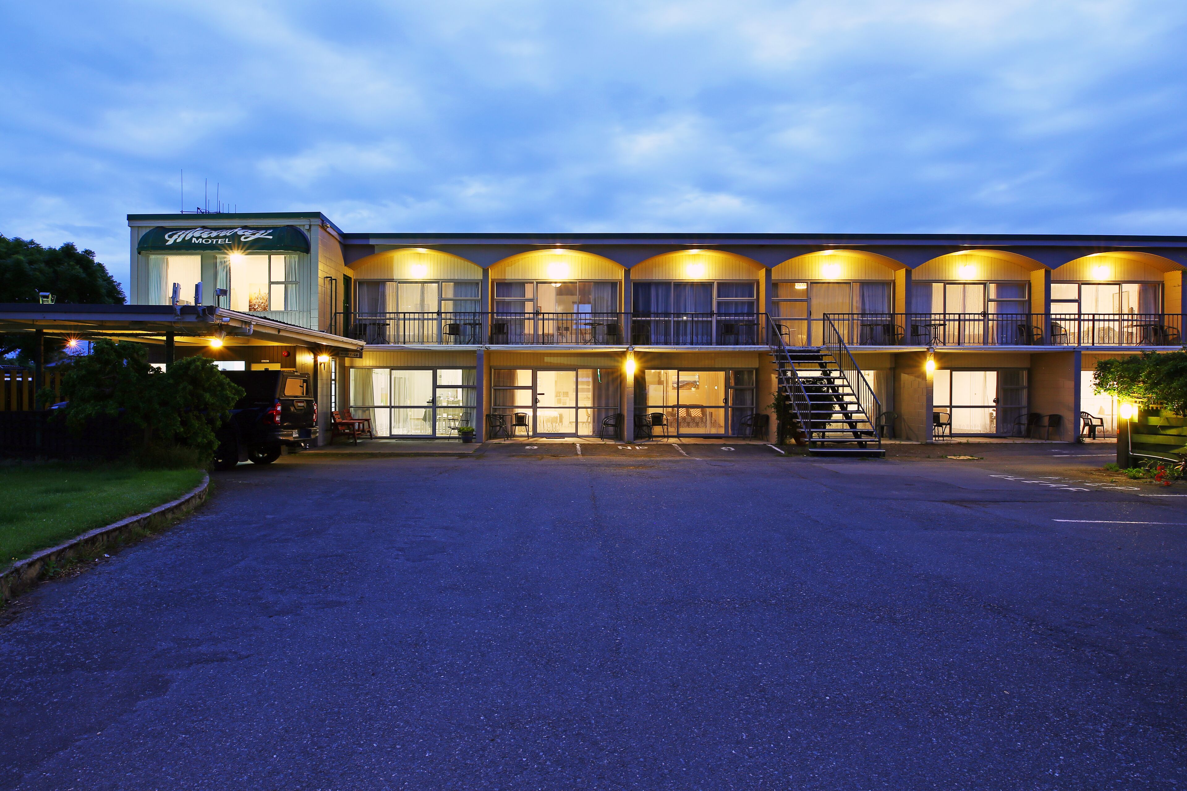 A motel with multiple balconies and a covered parking area.
