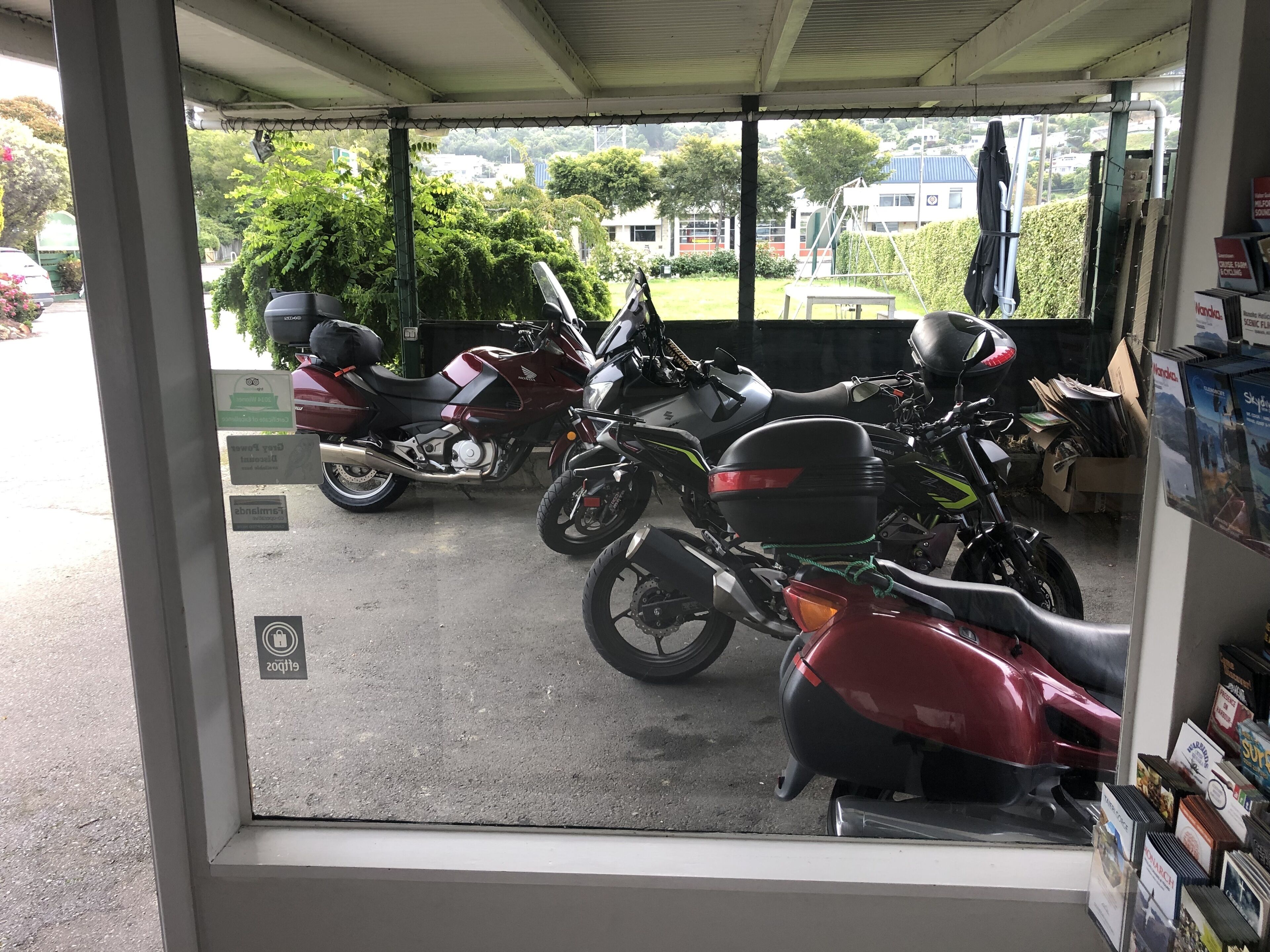 A motorcycle repair shop with several motorcycles parked outside.