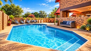 Piscina con sillones de descanso y una zona de recepción.