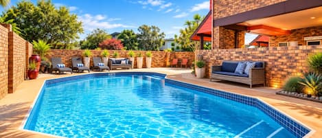 Piscina con sillones de descanso y una zona de recepción.