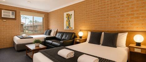 Ein Hotelzimmer mit einem großen Bett, einer Couch, einem Schreibtisch und einem Fenster mit Blick.