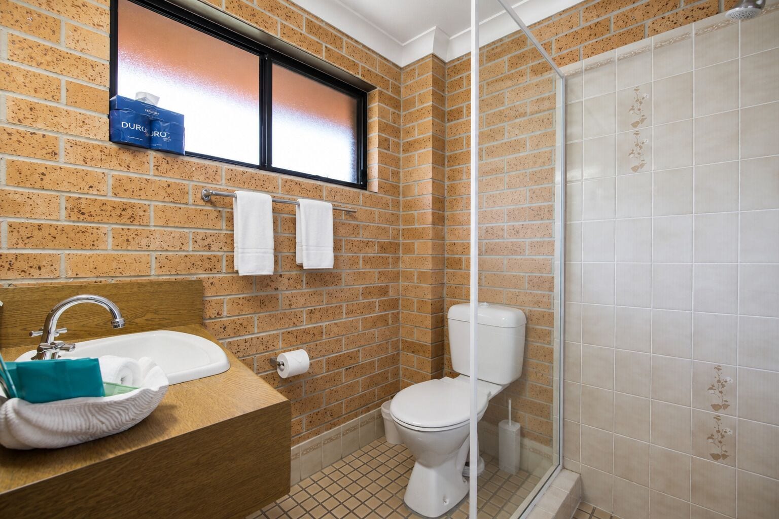 A bathroom with a sink, toilet, and shower.