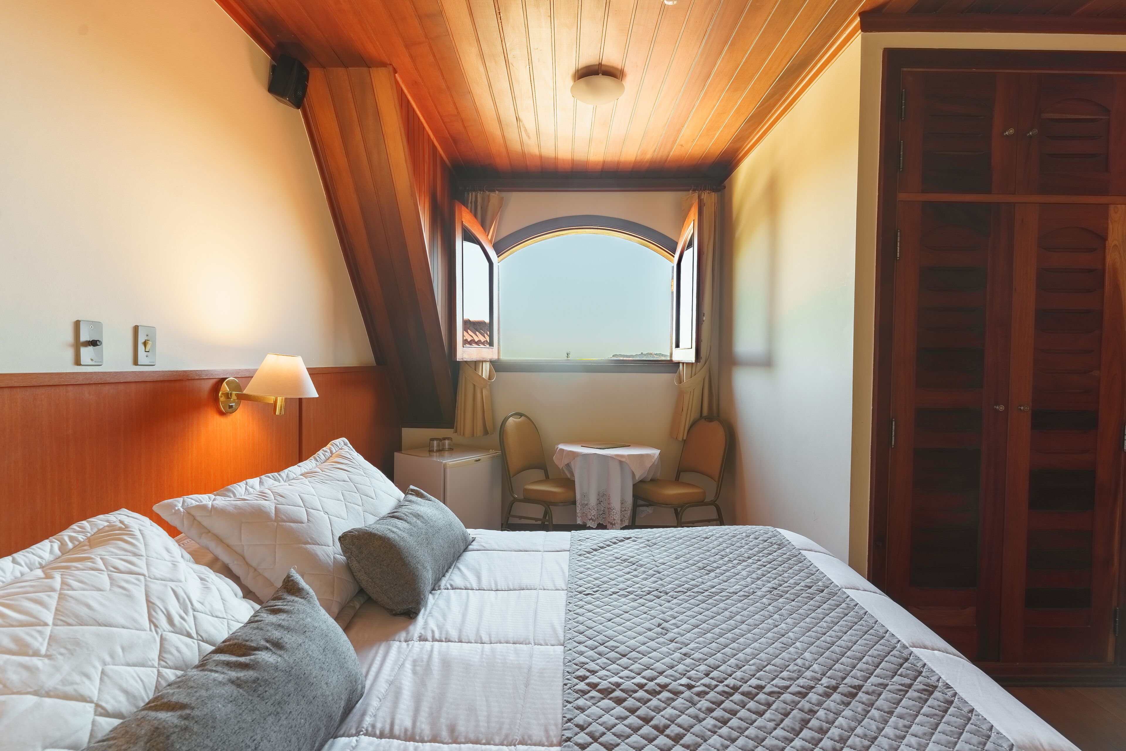 Une chambre d’hôtel comprenant un lit, un bureau, une chaise et une armoire.