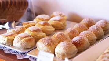 Diversos doces em uma bandeja, alguns polvilhados com açúcar de confeiteiro.